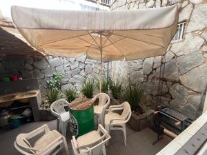 a patio with a table and chairs and an umbrella at Casa Quintal Bueno! 5 quartos com ar split e internet ultra! Perto do melhor de Goiânia! Marista Parques Areião e Vaca Brava Hospital Premium Mater Dei Blue Fit Perdomo Goiânia Shopping! in Goiânia