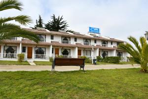 a building with a bench in front of it at Cabañas Rey Pacific in La Serena