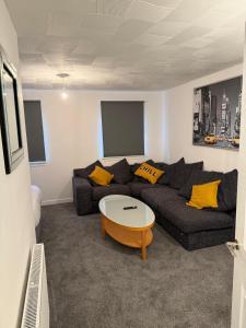 a living room with a couch and a table at 2-Bed City Apartment by Glasgow Green in Glasgow