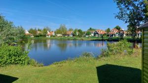 a large lake with houses in the background at Vakantiehuis Jade in Bruinisse