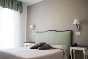 una camera con un letto con due cuscini sopra di Hotel Piccolo Mondo a Lido di Camaiore