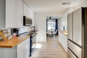cocina con armarios blancos y suelo de madera en Stroll to Shore Retreat with Yard in Daytona Beach, en Daytona Beach