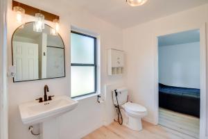 Un baño con lavabo, inodoro y espejo. en Stroll to Shore Retreat with Yard in Daytona Beach, en Daytona Beach 17 fotos más
