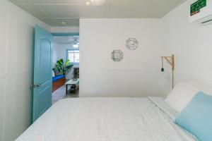 a bedroom with a bed and a blue door at Candyland Cabanas in Bocas del Toro