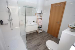 a bathroom with a shower and a toilet and a sink at Villa Punta Sol with jacuzzi in Jezera +26 photos