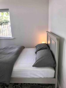 a bed with two pillows and a window in a room at PERIWINKLE COTTAGE, with the most amazing sea view in Youghal +10 photos