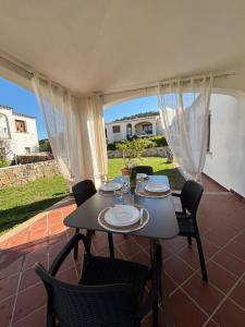 a dining room with a table and chairs on a patio at Su Nuraghe House in Tanaunella