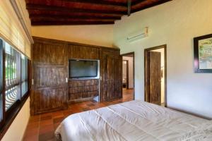 une chambre avec un lit et une télévision à écran plat dans l'établissement Topowa Club House Resort, à Girón