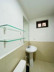 a white bathroom with a sink and a toilet at Casa San Juan 560 in Managua +10 photos