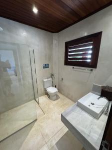 a bathroom with a toilet and a shower and a sink at App Queen Kite Village in Uruau
