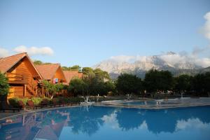 a large swimming pool with a mountain in the background at Woodline Hotel in Kemer