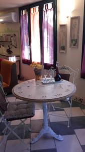 a table with two glasses and a bottle and two chairs at L'Antica Cantina in Usini