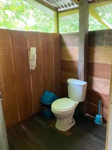 a bathroom with a toilet in a wooden stall at YAKU albergue y camping in Padre Cocha