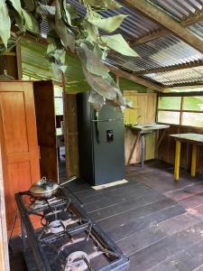 a kitchen with a stove and a green refrigerator at YAKU albergue y camping in Padre Cocha
