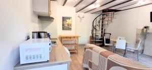 a kitchen with a counter with a microwave on a table at Le chant des bois - à 5 min du Château de Chenonceau in Chisseaux +15 photos