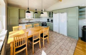a kitchen with green cabinets and a wooden table and chairs at 2 Bedroom Lovely Home In Uddevalla in Uddevalla