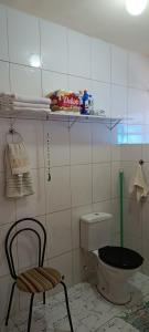 a bathroom with a toilet and a chair in it at Portais São Thomé casa de temporada in São Thomé das Letras +105 photos