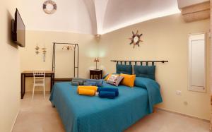 a bedroom with a blue bed with colorful pillows at A casa di Marina Mare Centro posto auto in zona in Porto Cesareo +65 photos