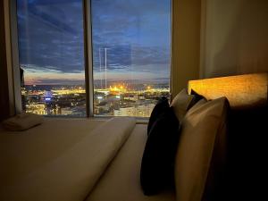 a bedroom with a view of a city from a window at Panoramic Sea View -13th Floor in Tallinn