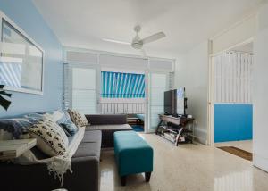 a living room with a couch and a tv at Oceanview Apartment Steps to the Beach in Luquillo