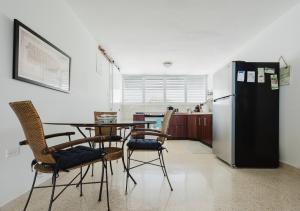 a kitchen with a table and chairs and a refrigerator at Oceanview Apartment Steps to the Beach in Luquillo