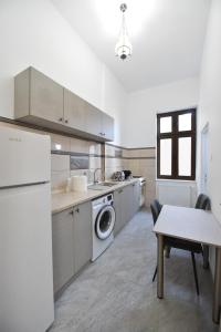 eine Küche mit einer Waschmaschine und einem Tisch in der Unterkunft BLISS HOUSE center in Oradea
