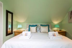 a bedroom with a large white bed with two lamps at Hunter Heights Loft (Countryside Views) in Wroxall