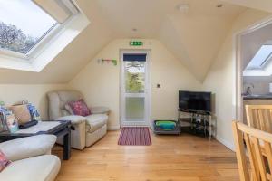 a living room with a couch and a tv at Hunter Heights Loft (Countryside Views) in Wroxall