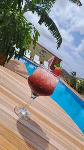 a drink in a glass on a table next to a pool at Bangaló Buzio Relax in Portal