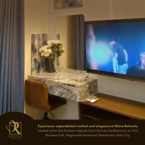 Eine Vase mit Blumen steht auf einem Tisch neben einem Fernseher. in der Unterkunft Luxury Condo in Iloilo City by Eliara Retreats in Iloilo City