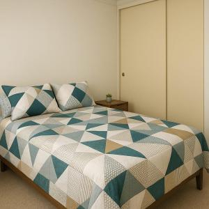 ein Schlafzimmer mit einem Bett mit einer blau-weißen Steppdecke in der Unterkunft Antofagasta Centro Moderno Dpto 1 Habitacion in Antofagasta