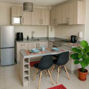 eine Küche mit einem Tisch mit Stühlen und einem Kühlschrank in der Unterkunft Antofagasta Centro Moderno Dpto 1 Habitacion in Antofagasta