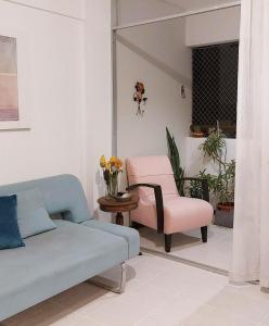 a living room with a couch and a chair at Quarto e Sala Temporada no Rio Vermelho in Salvador