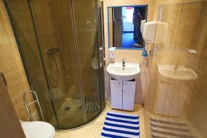 ein Bad mit einer Dusche und einem Waschbecken in der Unterkunft HELLO Gdynia Hostel in Gdynia