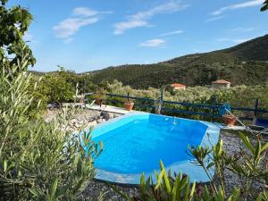 a swimming pool with a mountain in the background at Happynest Leni, Stone House in Dhernikaíika