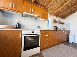 a kitchen with wooden cabinets and a white oven at Happynest Leni, Stone House in Dhernikaíika