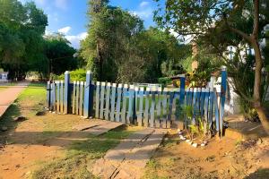 a white picket fence in front of a street at Casarão Miguel Pereira - Refúgio na Natureza com Lareira Externa, Piscina, Fondue e Amplo Jardim - 12 Min do Parque Terra dos Dinos in Miguel Pereira