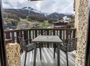 レ・ゾルにあるRésidence Le Cairn - Joli studio 4 personnes au centre des Orres 1650 MAE-0343の眺めの良いバルコニーにテーブルと椅子が置かれている