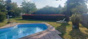 a small swimming pool in a yard with a chair at Les Gîtes de la Cour au Mercier in Teillay