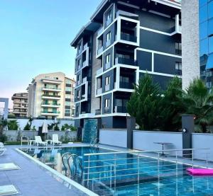 ein Schwimmbad vor einem Gebäude in der Unterkunft Neridabeachhomes 17 in Alanya