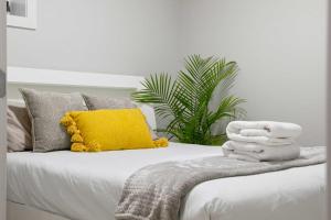 a white bed with a pile of towels on it at Modern 2BR Private Suite NW Near Airport & Amazing Shopping! Free Banff Pass, Netflix, Parking! in Calgary