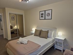 a bedroom with a white bed and a mirror at Spacious Modern 2-BR Apartment in Aberdeen City Centre in Aberdeen