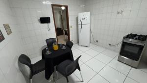 a kitchen with a table and chairs and a refrigerator at Casa da Sementes in Uberlândia