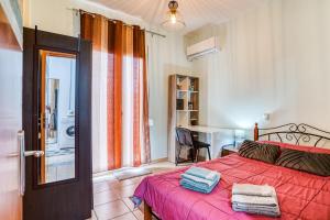 a bedroom with a red bed with a red blanket at Mrs, Aphrodite's Studio in Chios +7 photos