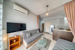 a living room with a couch and a flat screen tv at Mrs, Aphrodite's Studio in Chios