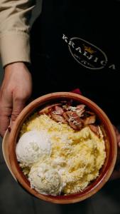 ドボイにあるKraljičini konaciのチーズの入ったボウルを持った人
