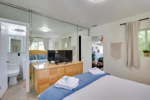 a bedroom with a bed and a sink and a mirror at Walk to Ocean Chic Deerfield Beach Cottage! in Deerfield Beach
