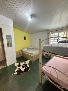 um quarto com dois beliches e um tapete de vaca em Kitnet Aconchegante Simples e Bem Localizada em Serra Negra