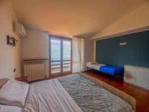 a bedroom with two beds and a large window at Appartamento a due passi dal lago con box in Dorio