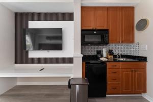 a kitchen with a black refrigerator and a microwave at 2 Units Together Kitchen Great Location in Orlando